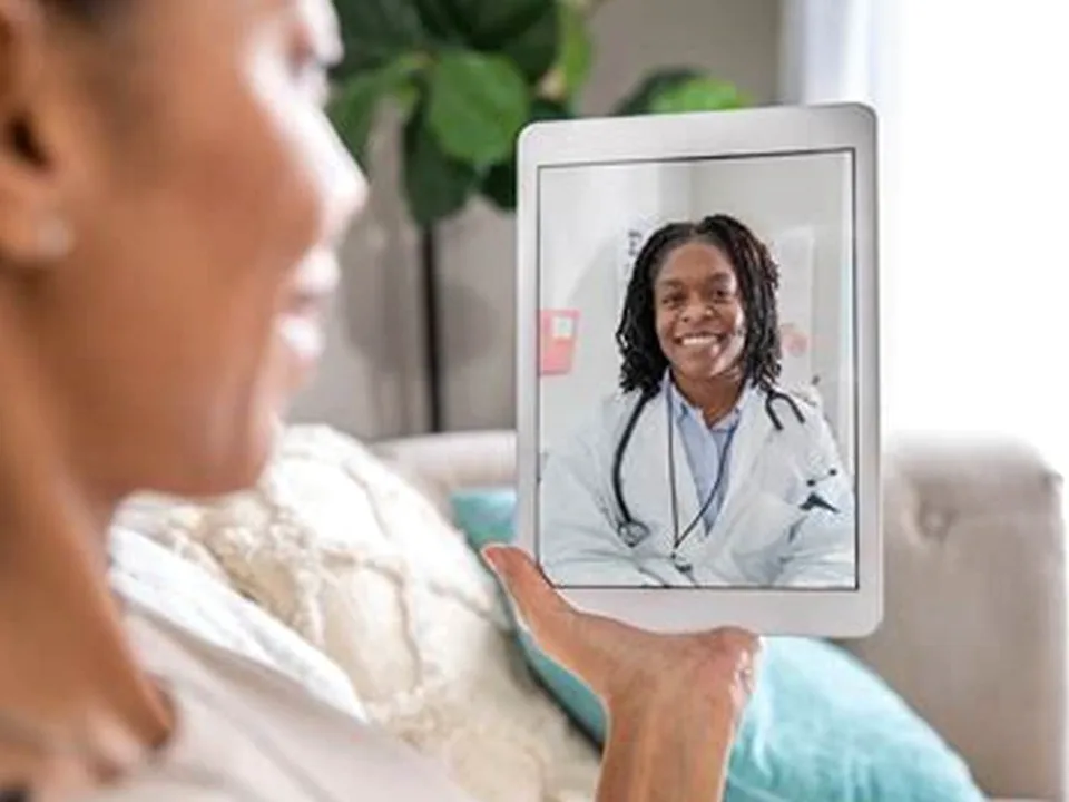 A clinician on a telehealth video call explaining what estradiol is to a patient
